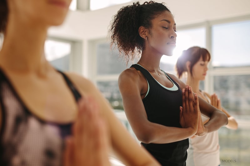 Three women doing yoga in a studio.
