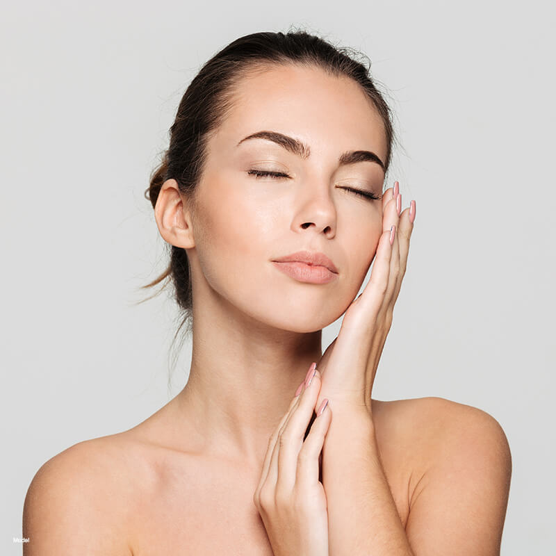 Young woman touching her face