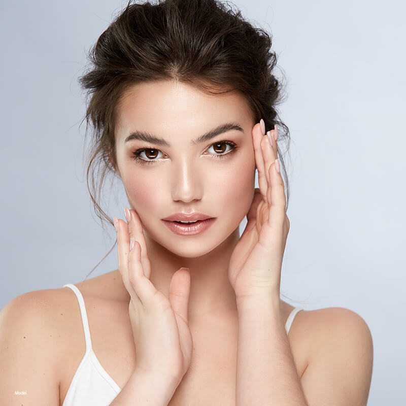 young woman touching her face