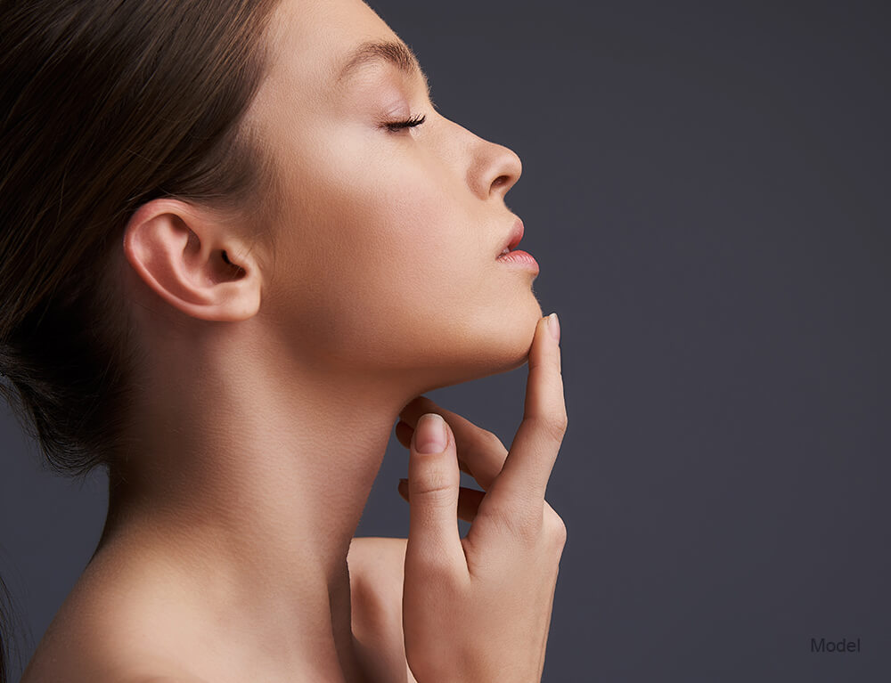 Profile of a young woman touching her chin